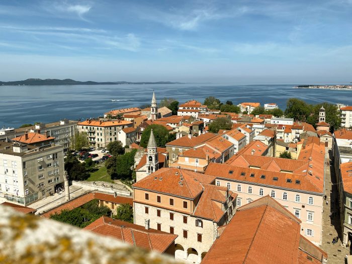 Aerial view of Zadar, Croatia with red-roofed buildings and the sparkling Adriatic Sea along the Dalmatian coast