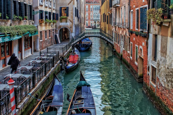 A small ship floating on a peaceful canal in Venice surrounded by historic buildings