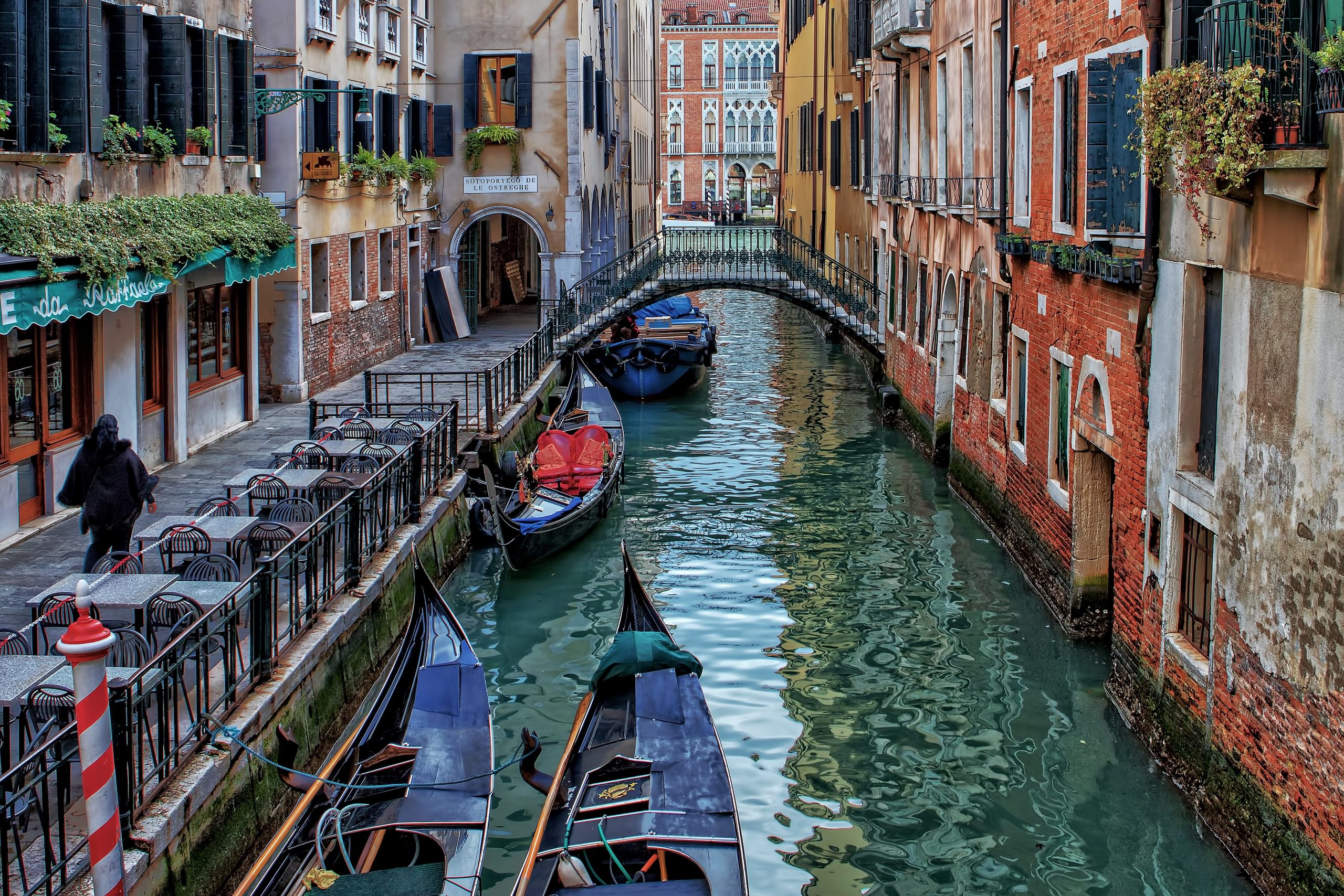 A small ship floating on a peaceful canal in Venice surrounded by historic buildings